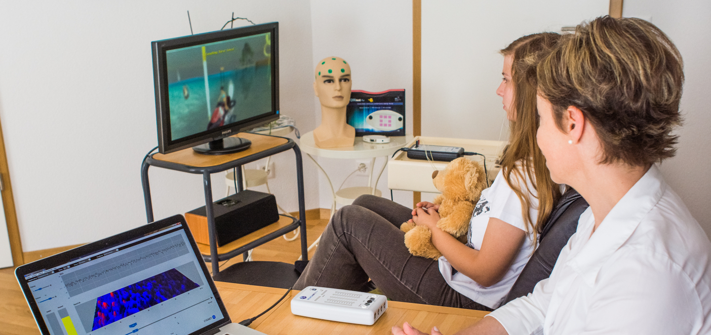 Patient undergoing neurofeedback therapy with EEG monitoring and brain training software at a BEE Medic clinic.